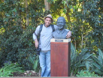 A visitor posing with a statue bust