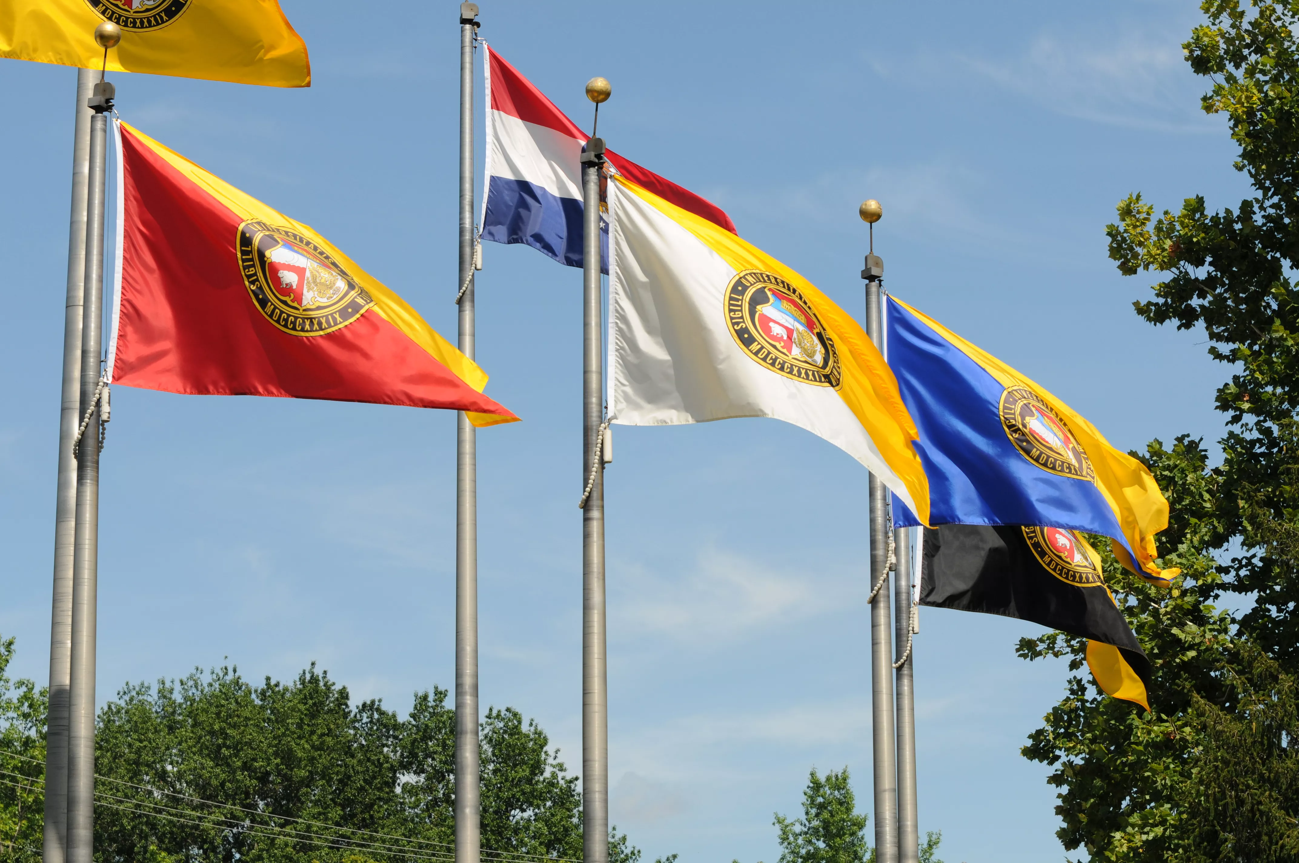 all four UM System flags on flagpoles