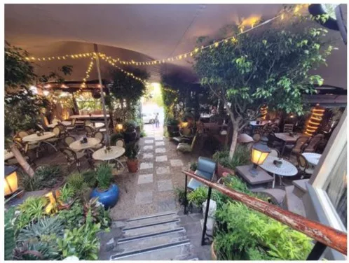 Restaurant courtyard under a tent with lights strung along the top.
