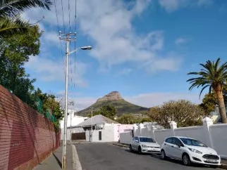 Lions Head Mountain rises above a city street.