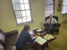 John sits across from Dr. Pieter Groenewald during an interview