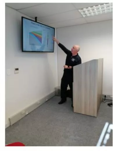 Kevern points to a screen while giving a lecture