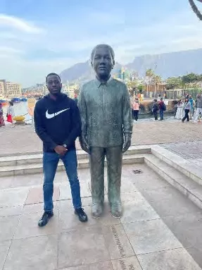 Abeeb with a statue of Nelson Mandela at the V&A Water Front