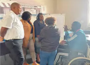 A group of five people have a discussion