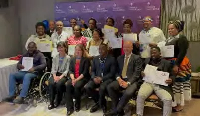 Faculty and community members pose holding certificates after the training. 