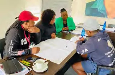 Four people sit around a table looking at papers