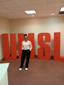 Zolenka poses in front of an UMSL lettered sign