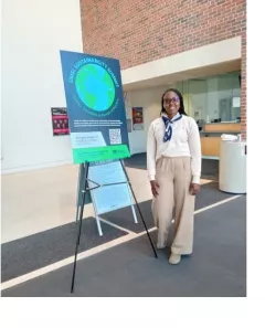 Zolenka with a sign for the UMSL Sustainability Summit