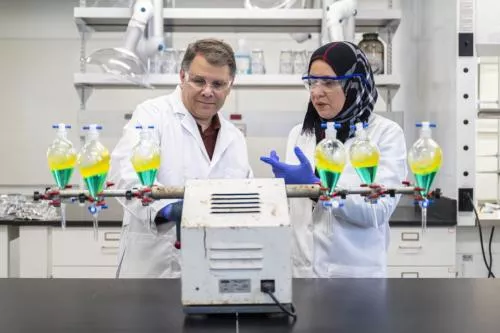 Two Missouri S&T researchers at a lab bench operating an analysis machine