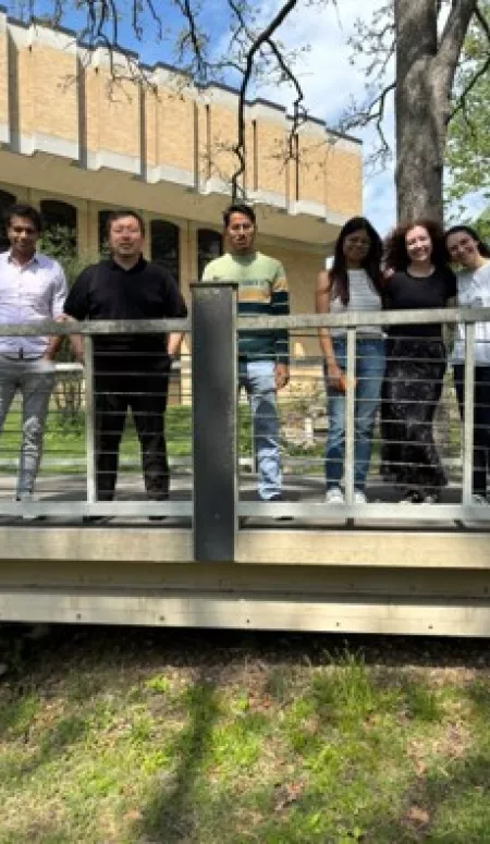 Six people pose on a walking bridge at Missouri S&T, including Dr. Dinda